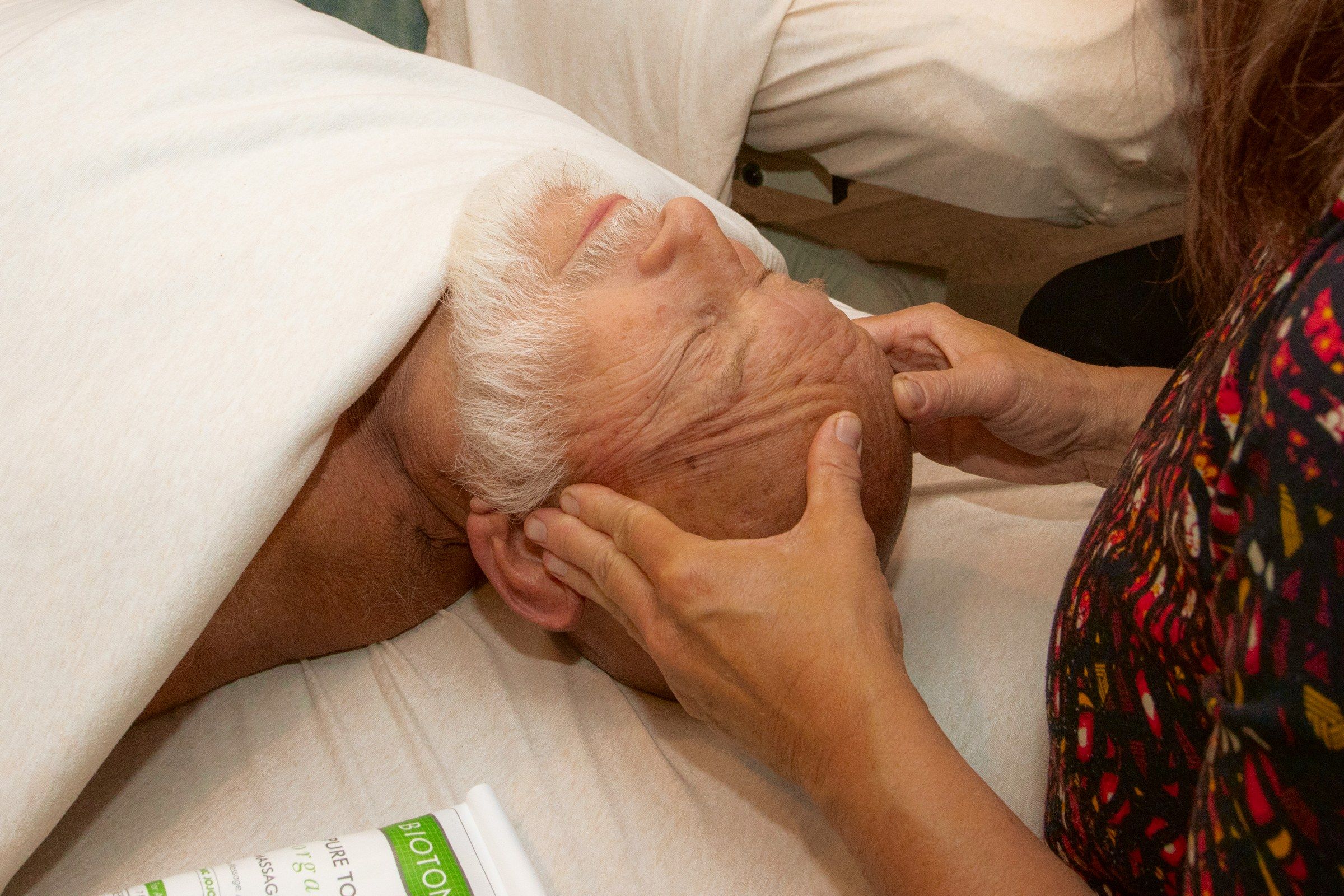 A couples session: hands cradling a client's head