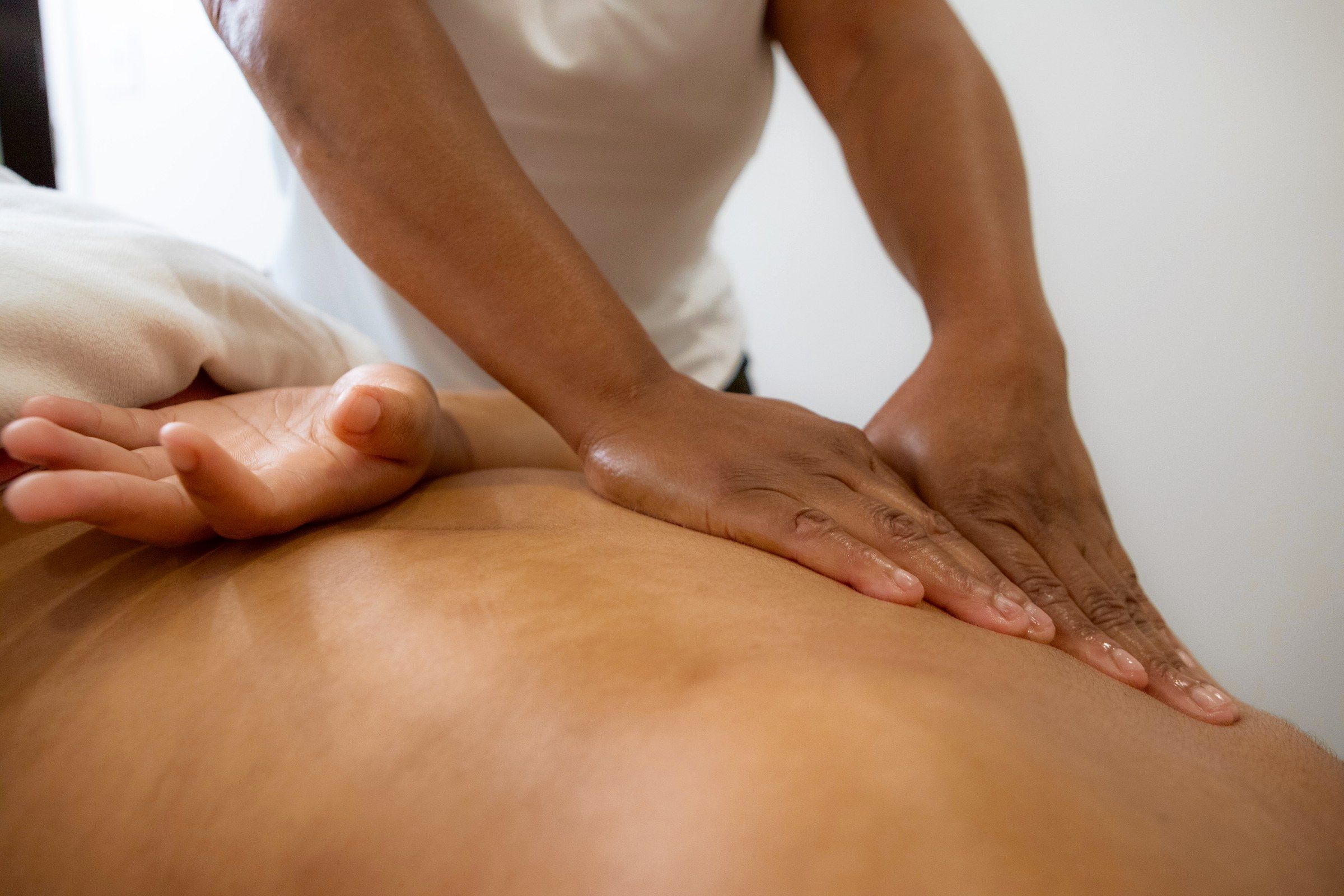 Alecia's hands in long strokes down a client's back