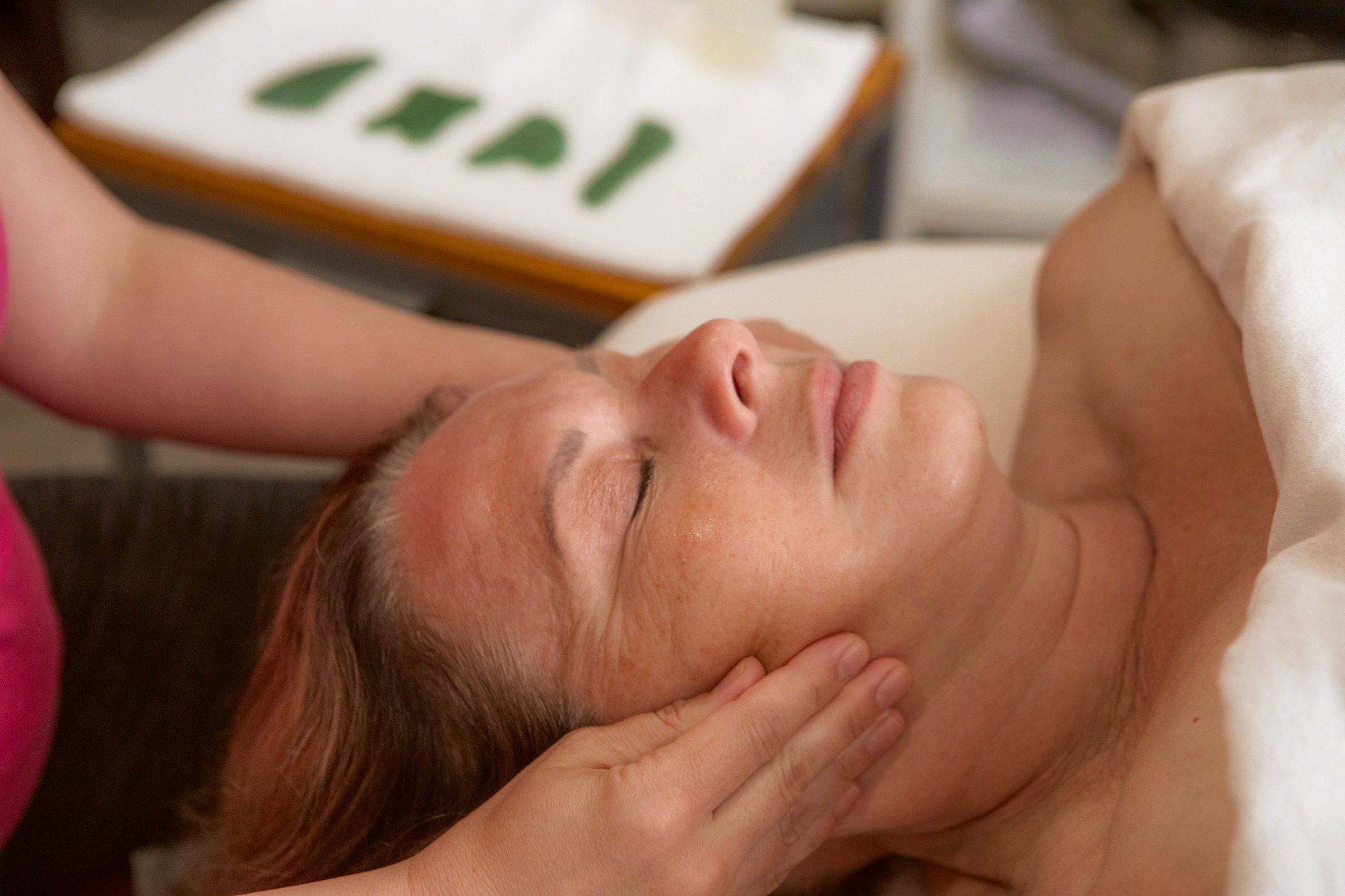 Krissy's hands cradling a client's face