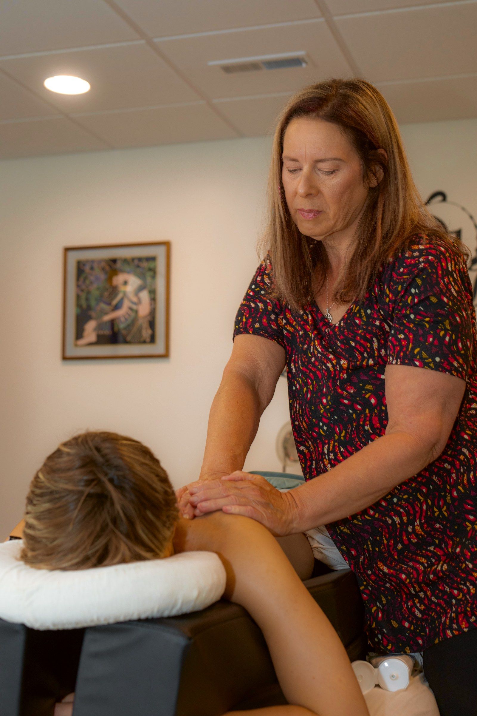 Prenatal massage in the treatment room, the client on a pregnancy cushion