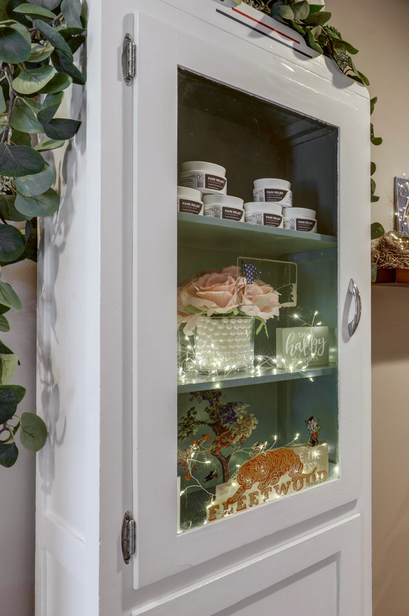 A glass cabinet of oils and crystals in the hallway