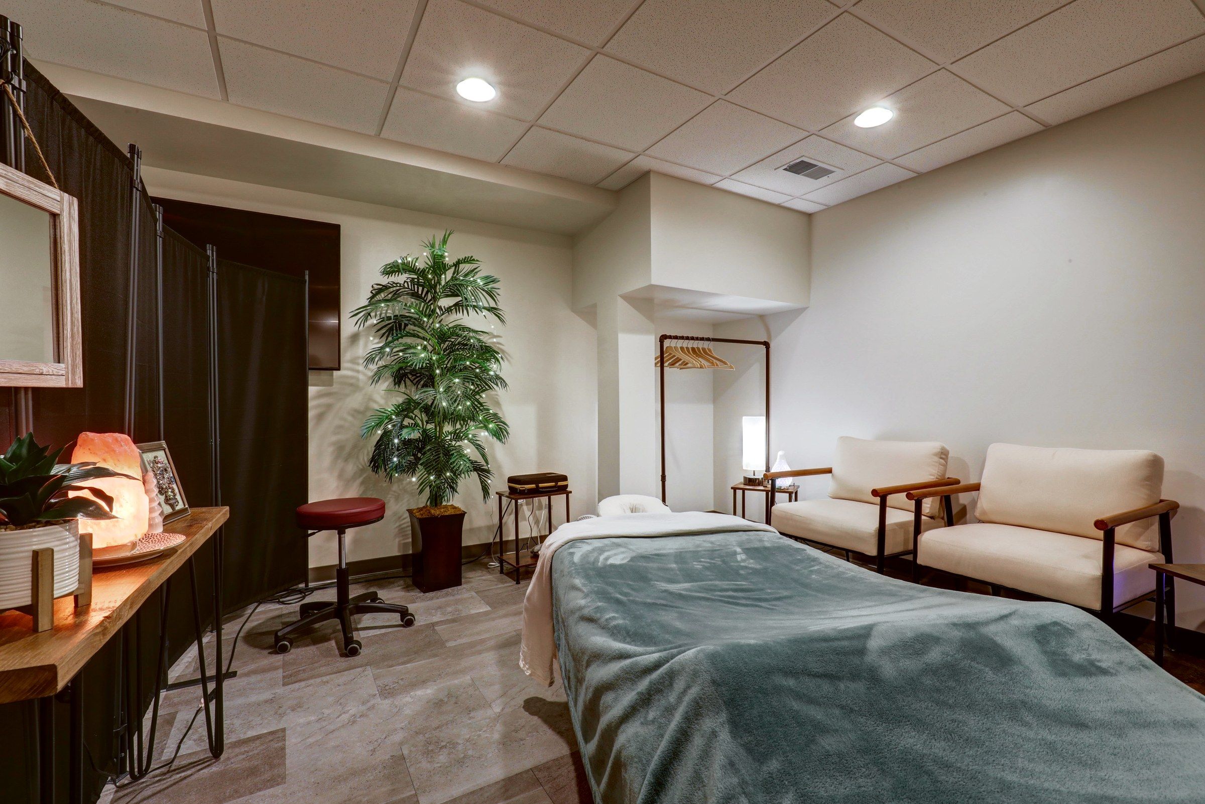 Treatment room with dark folding screens and a salt lamp